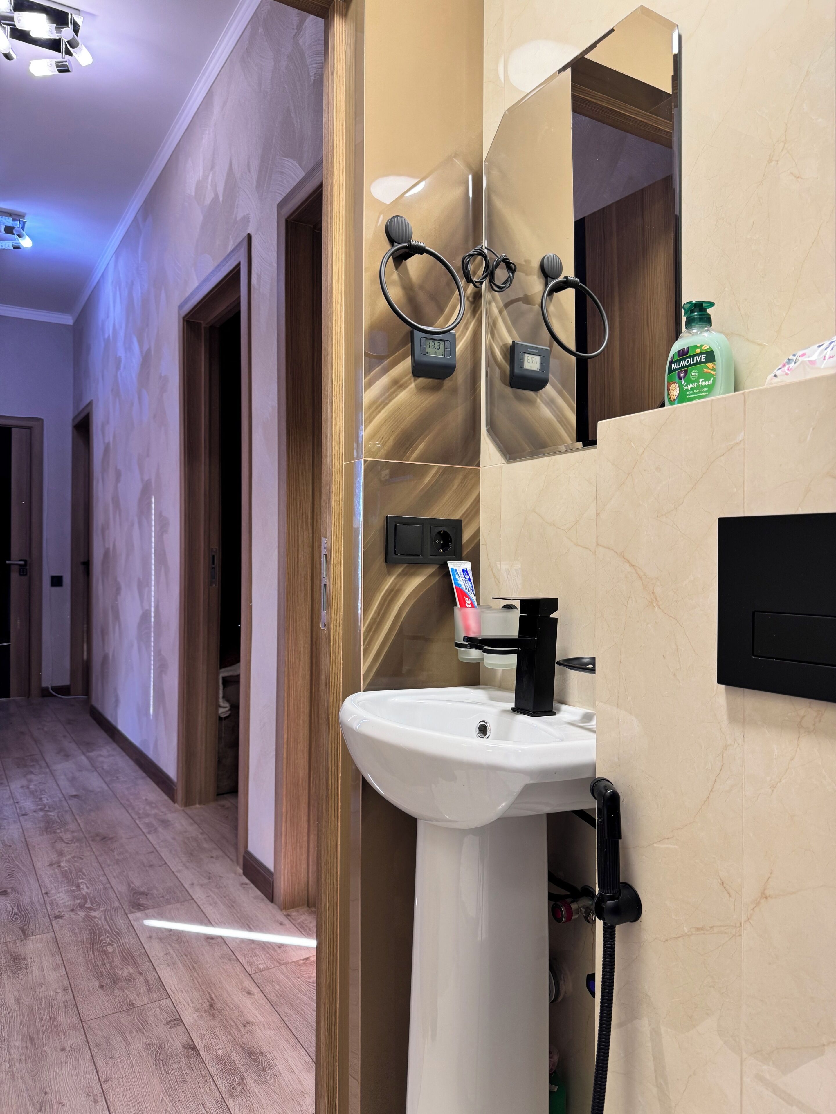 Een moderne badkamer met een wit wastafelmeubel, een spiegel en een handdoekhouder.