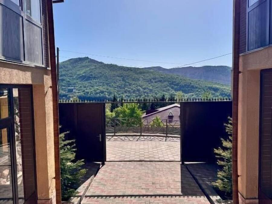 A building with a paved entrance and a view of a mountain.