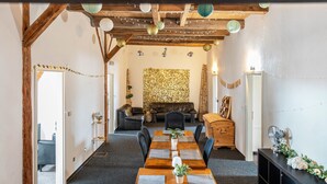 Un espace repas avec une longue table, des chaises et une structure de plafond en bois.