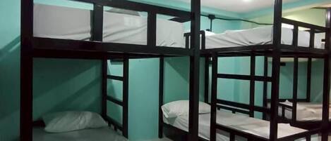 Bunk beds in a room with teal walls and a tiled floor.