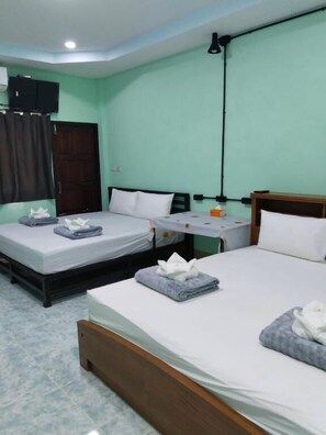 A hotel room with two beds, a desk, and a wardrobe.