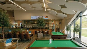 A billiards table, seating area, and a bar with a menu display. - Pine Lodge Spa Pet (Thirsk)