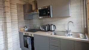 A modern kitchen with a built-in microwave, toaster, kettle, and stainless steel sink. - Pine Lodge Spa Pet (Thirsk)