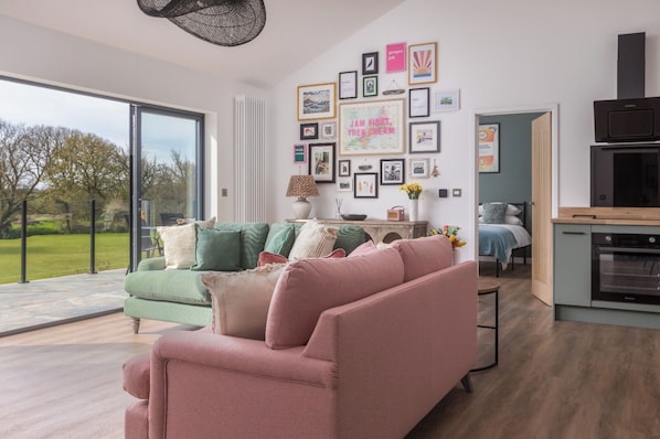 Un salon moderne comprenant un canapé, une table basse et un coin cuisine avec une cuisinière.