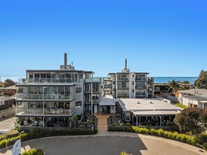 Un hotel modern amb diverses plantes, grans finestres i vistes a l'oceà.
