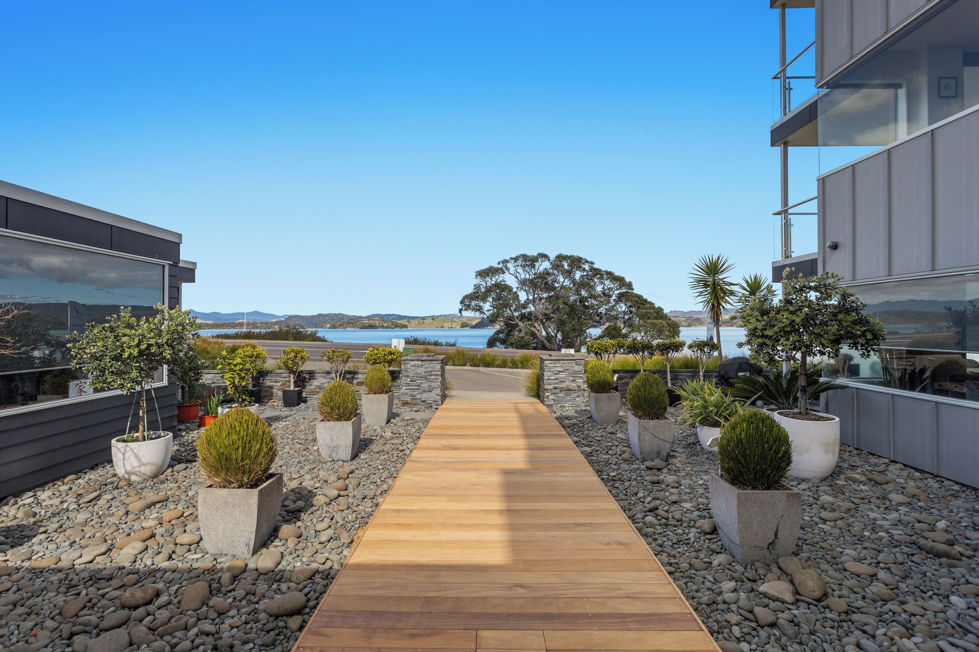 A pathway leading to a building with a view of the sea.