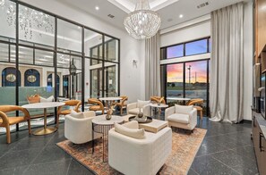 A modern hotel lobby with a seating area, large windows, and a chandelier. - Cozy 2-bedroom apartment with AC in delightful Round Rock (Round Rock)