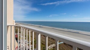 Un balcon avec vue sur la plage et l’océan.