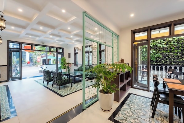 A modern interior with a reception desk, seating area, and a view of the street.