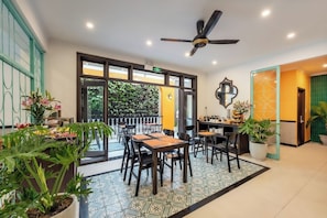A hotel lobby with a dining area, a ceiling fan, and a wall-mounted mirror.
