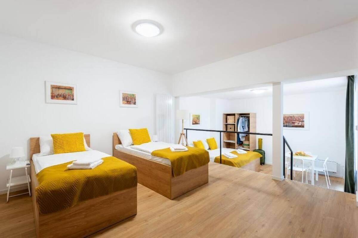 Une chambre d’hôtel moderne avec deux lits, un bureau et une chaise.