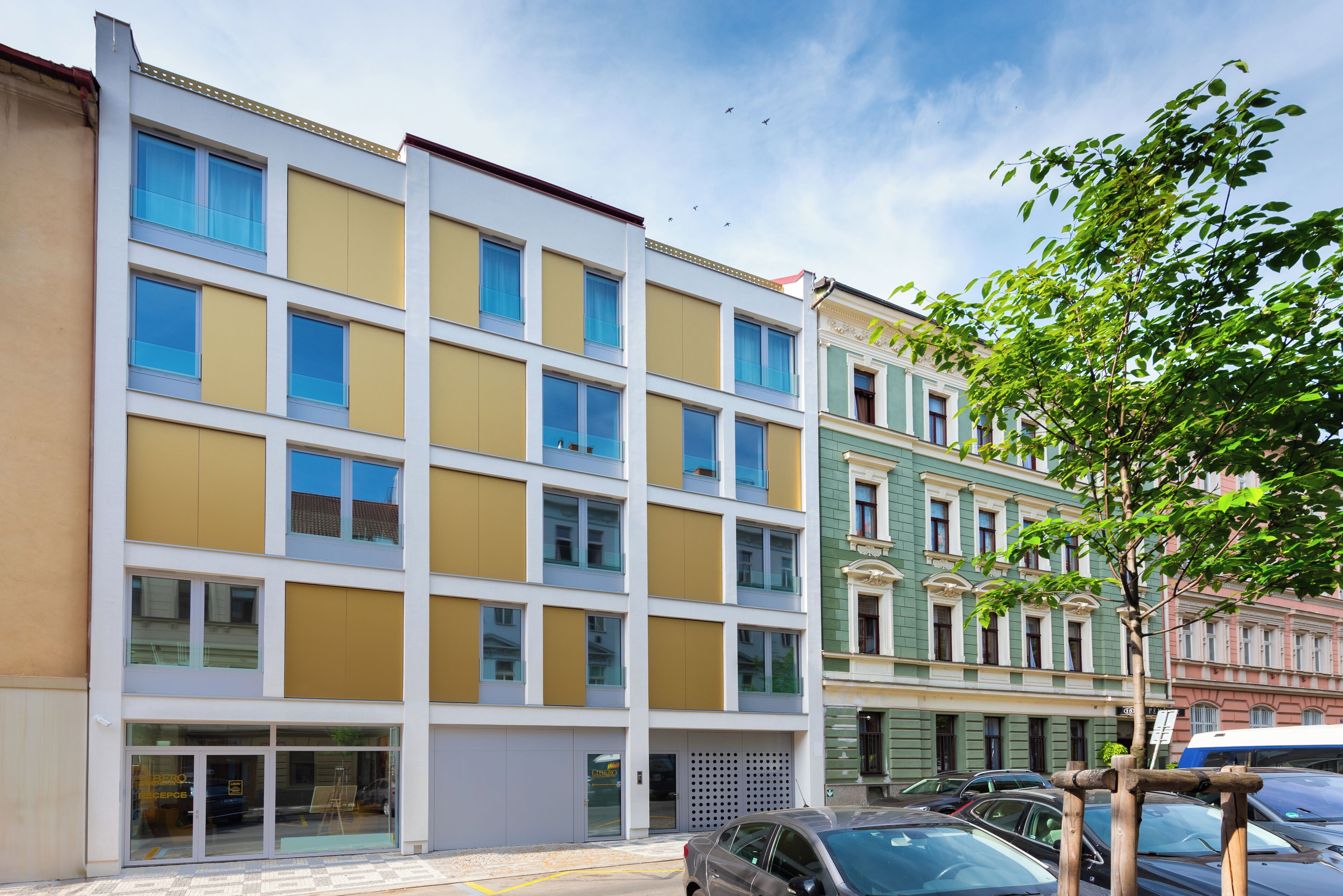 Ein mehrstöckiges Gebäude mit zeitgemäßem Fassadendesign, großen Fenstern und einem gut sichtbaren Eingang.