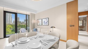 A modern dining room with a large table set for six, large windows with a city view, and a wooden accent wall. - 2BR Address Residences Dubai Opera, Burj Khalifa View from all the rooms (Dubai)