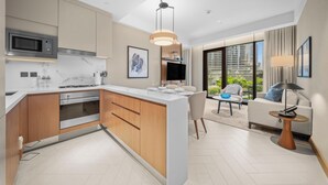 A modern kitchen with a built-in microwave, oven, and a large island with seating. - 2BR Address Residences Dubai Opera, Burj Khalifa View from all the rooms (Dubai)
