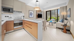 A modern kitchen with a built-in microwave, oven, and a large island with seating. - 2BR Address Residences Dubai Opera, Burj Khalifa View from all the rooms (Dubai)