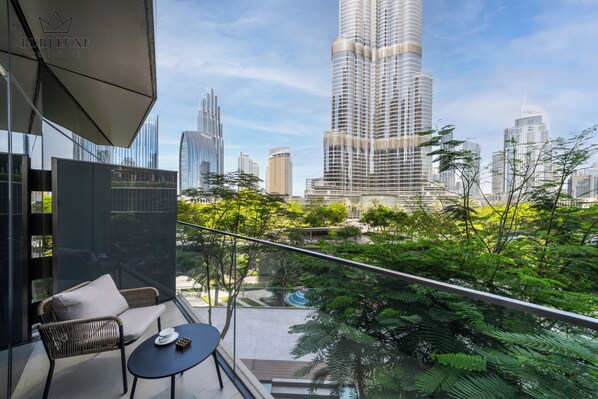 A balcony with a view of a cityscape, including tall buildings and greenery. - 2BR Address Residences Dubai Opera, Burj Khalifa View from all the rooms (Dubai)