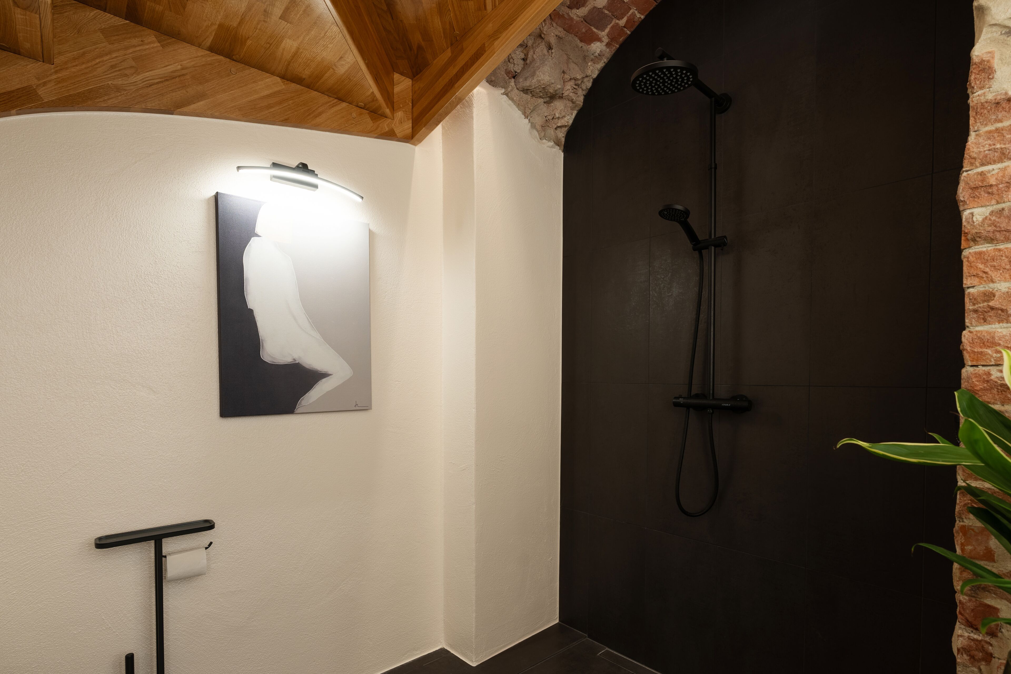 Une salle de bain moderne équipée d’une douche, d’un porte-serviettes et d’un luminaire fixé au mur.