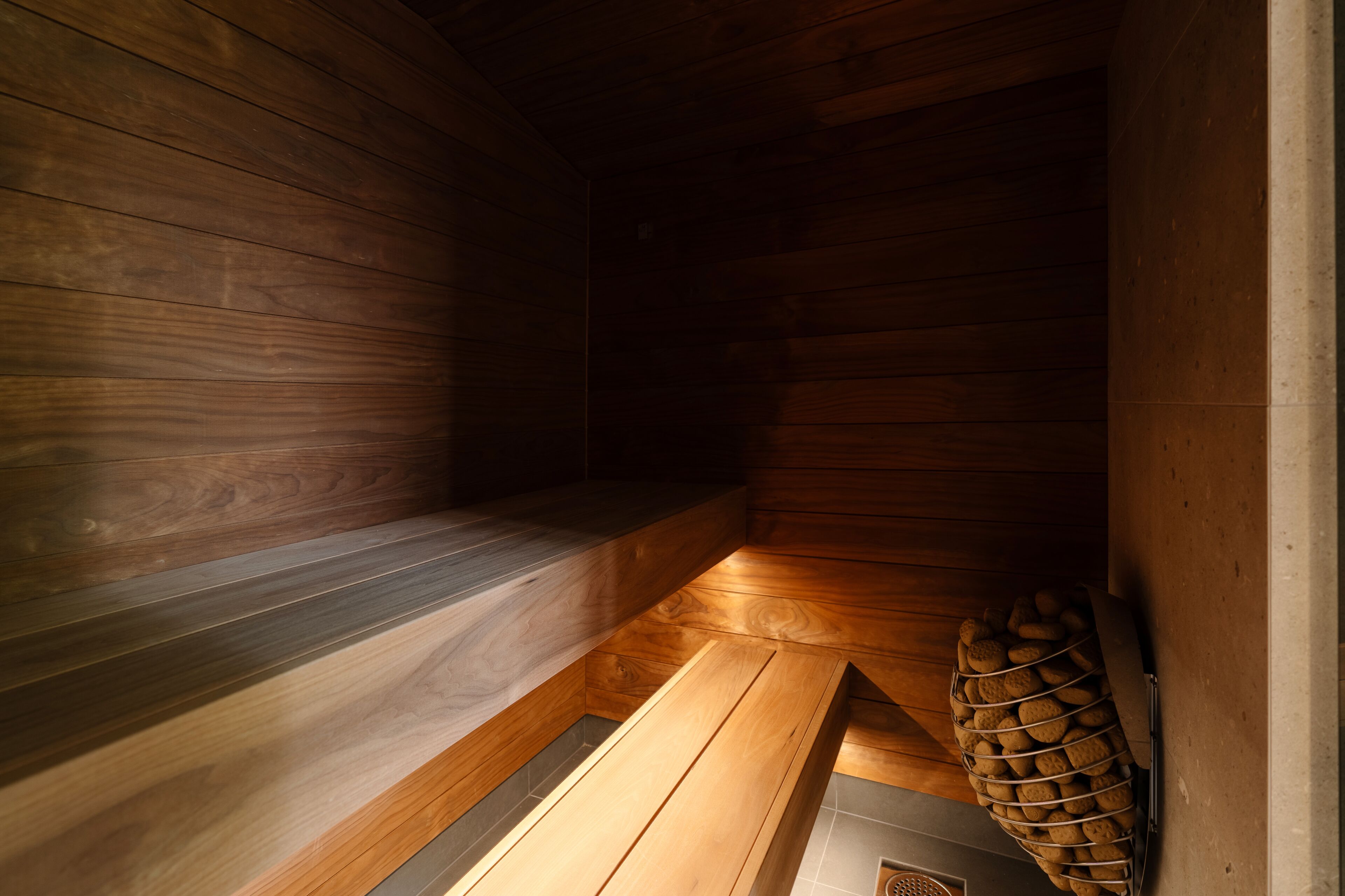 Un sauna avec des murs et des bancs en bois.