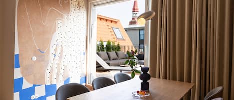 A dining area with a table, chairs, and a vase with flowers.