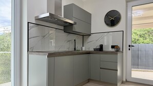 Une cuisine moderne équipée d’une cuisinière intégrée, d’une hotte aspirante et d’une horloge murale.