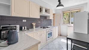 A kitchen with white cabinets, a gas stove, a toaster, and a kettle. - Superb Apartment with Panoramic View – Sleeps 8 – Marseille 9th District (Marseille)