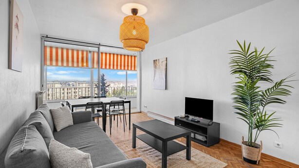 A modern living room with a sofa, coffee table, TV, and a large window with a view. - Superb Apartment with Panoramic View – Sleeps 8 – Marseille 9th District (Marseille)