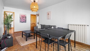 A modern dining area with a dark table, black chairs, a woven pendant light, a wooden door, and a radiator. - Superb Apartment with Panoramic View – Sleeps 8 – Marseille 9th District (Marseille)