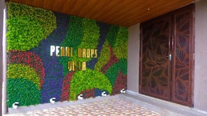 A wall with a colorful floral design and a wooden door with leaf patterns.
