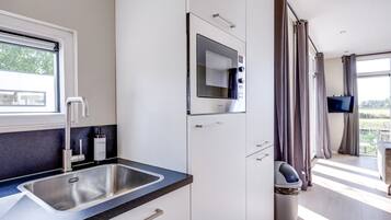 A modern kitchen with a built-in microwave, a sink, and a window.