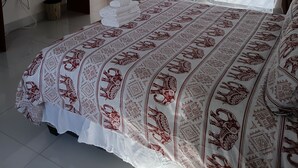 Een slaapkamer met een bed, een bureau, een televisie en uitzicht.