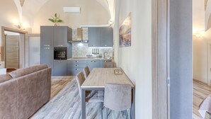 Una cocina moderna con armarios grises, una mesa de comedor y un sofá.