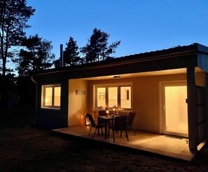 A small house with a patio, a table with chairs, and a door. - Relaxation near the Baltic Sea and Bodden - view of nature, with terrace and fireplace (Pruchten)