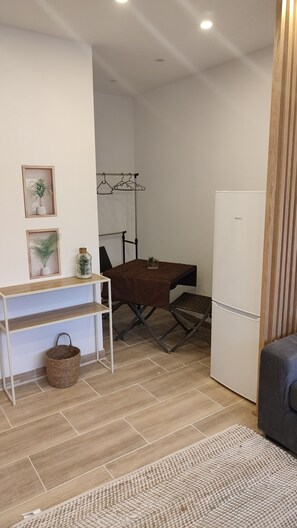 A compact living space with a dining table, a sofa, a small refrigerator, and a wooden cabinet. - 15 min from the southern beaches, between vaunage and camargue🌞 (Aimargues)
