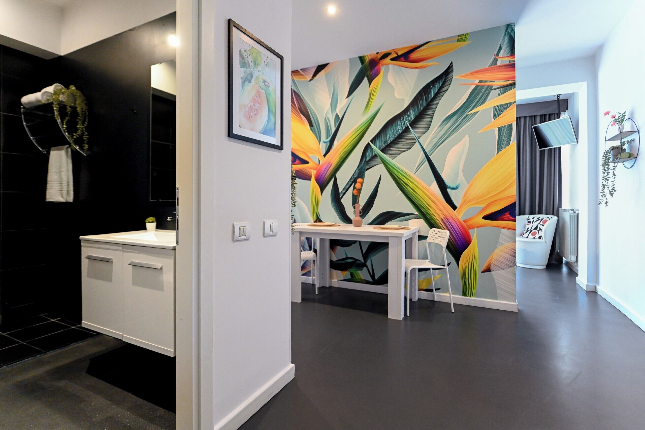 A modern bathroom with a white sink, a mirror, and a shower area.