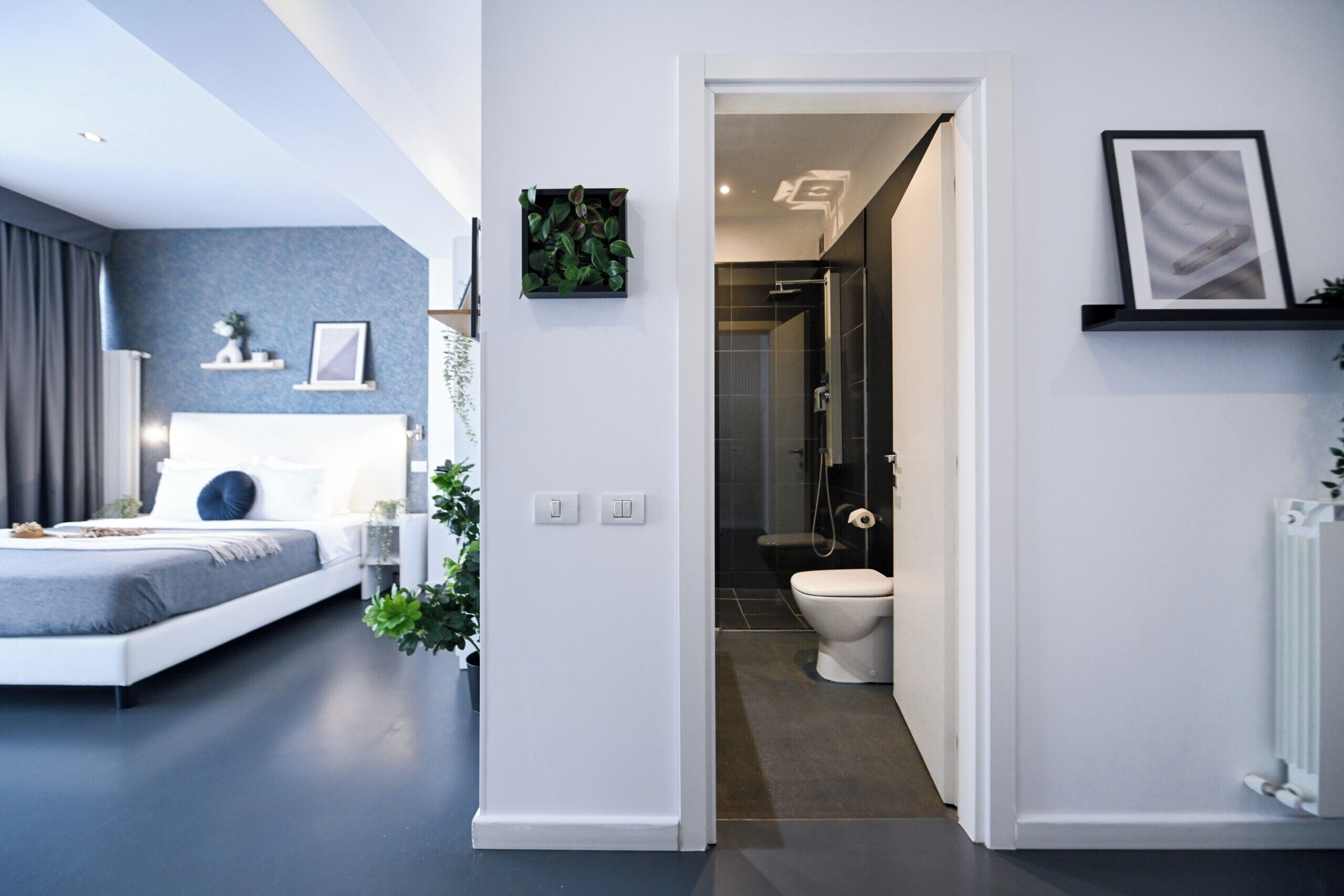 Een moderne slaapkamer met een bed, nachtkastje en een bedtafel.