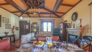 A dining area with a table set for four, a chandelier, and a fireplace. - Holiday Home Los Miradores, Marchena, Seville (Marchena)