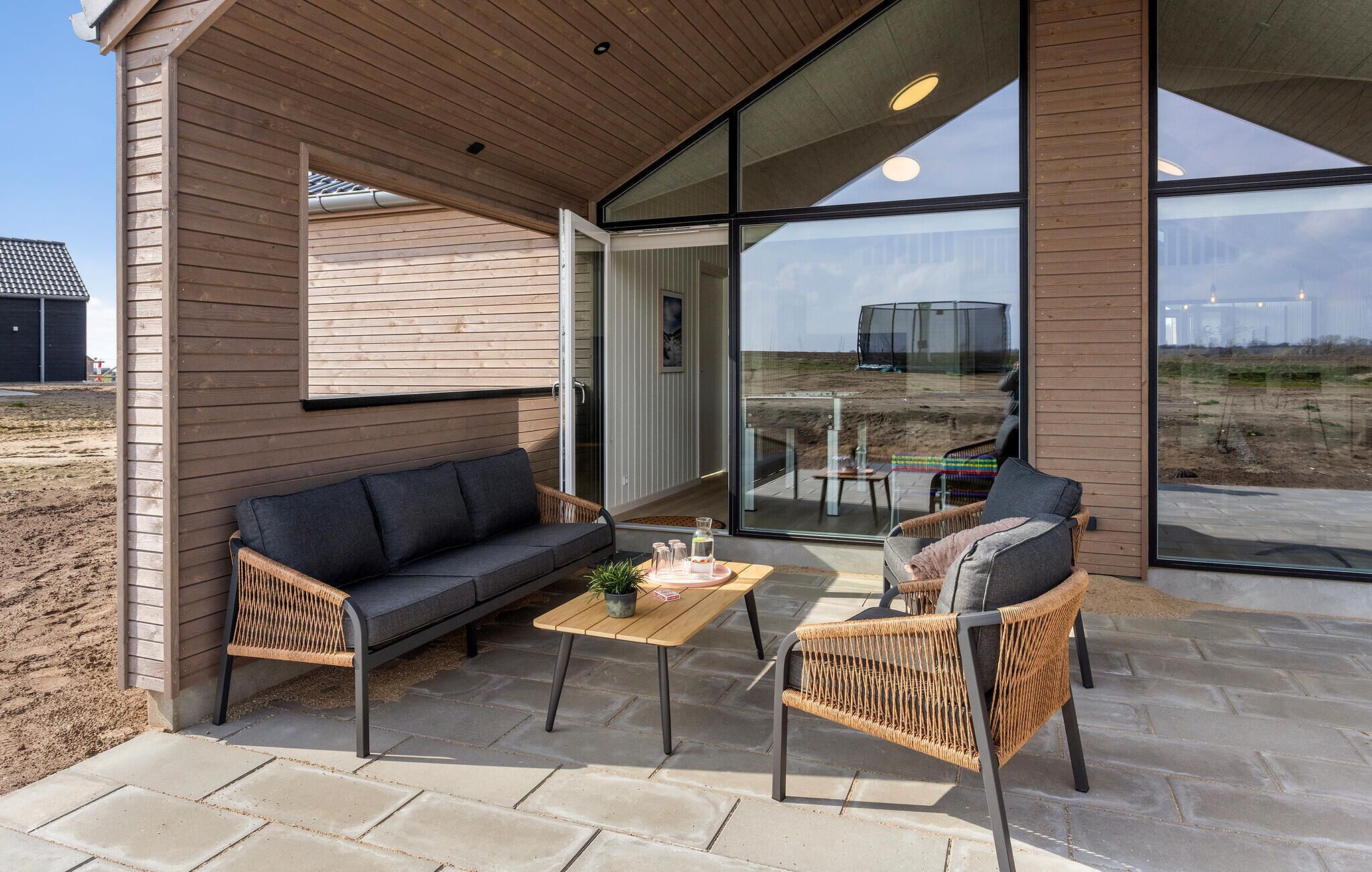 Un espace extérieur aménagé, abrité et doté d’un canapé, de chaises et d’une table.