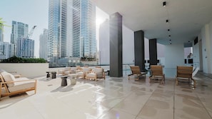 Eine moderne Dachterrasse mit Sitzgelegenheiten und Blick auf einen Pool.