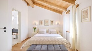 A bedroom with a bed, bedside tables, a bench, a mirror, and framed pictures on the wall. - Casa Pove by Villas Guide (Baredine)