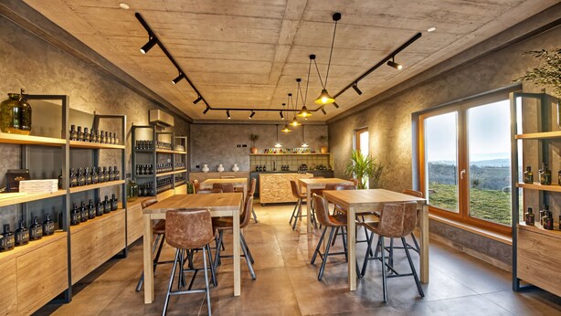 A modern interior with a bar area, wooden furniture, and a view through large windows. - Casa Pove by Villas Guide (Baredine)