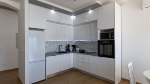 Eine moderne Küche mit weißen Schränken, einer eingebauten Mikrowelle und einem Backofen.