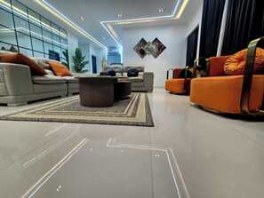 A modern living room with a sofa set, a coffee table, and a rug. - Stan Haven Apartment (Abuja)