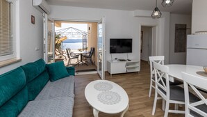 Un salon moderne avec un canapé, une table à manger et un téléviseur.