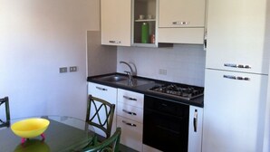 A compact kitchen with a sink, stove, and cabinets. - Verde Mare Beach Houses (Contrada Taverna)