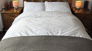 A neatly made bed with a wooden headboard, three framed pictures on the wall, and two bedside lamps. - SPACIOUS 3 BEDROOM VICTORIAN FLAT IN DUNFERMLINE. VERY NEAR TOWN CENTRE ! (Dunfermline)