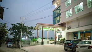A hotel with a covered entrance, a sign indicating 'Hotel Airport View,' and a paved driveway with parked cars.