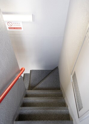 A staircase with a handrail, carpeted steps, and a no-smoking sign on the wall. - Ustay nippori (Tokyo)
