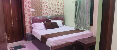 Un dormitorio con cama, un armario de madera, una mesita de noche y una ventana con cortinas.