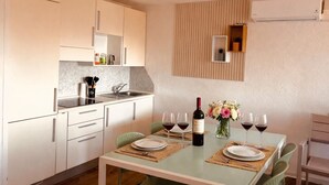 Een compacte keuken met een eethoek, inclusief een tafel gedekt voor vier personen met wijnglazen en een fles wijn.