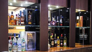 Zona de bar con varias botellas de licores y un teléfono en la barra.